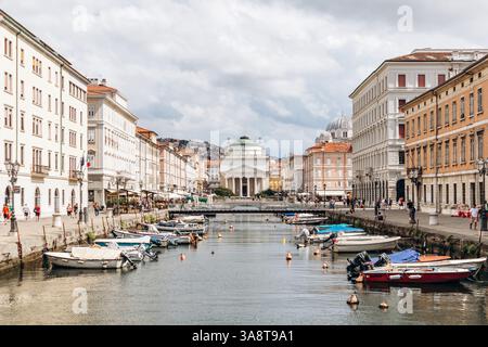Trieste, Italie - 18 août 2024 : vue sur le canal Grande à Trieste, avec des bateaux et des bâtiments colorés bordant le front de mer Banque D'Images