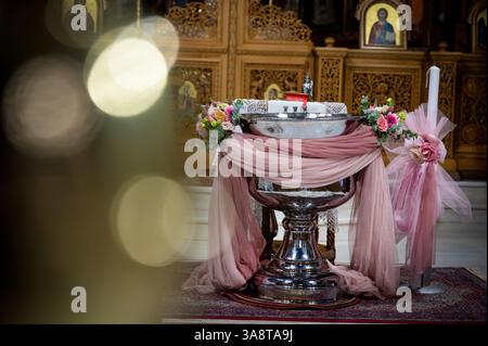 Les saints fonts baptismaux à l'intérieur d'une église orthodoxe grecque, décorée pour le baptême d'une fille Banque D'Images