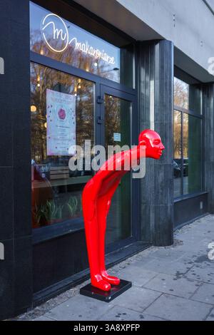 Varsovie, Pologne. 27 janvier 2025 - sculpture rouge unique devant le restaurant Makaroniarze. Banque D'Images