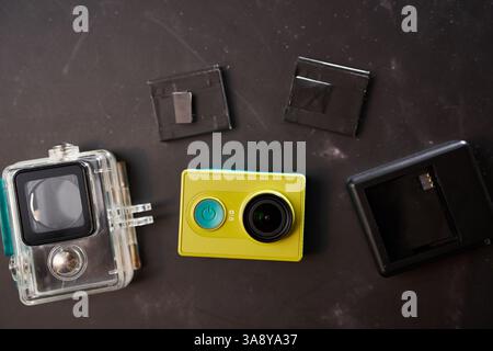 États-Unis, Arizona - 10 mars 2025 : caméra d'action Xiaomi Y1 jaune avec un boîtier transparent, un chargeur et des piles remplaçables se trouve sur la table Banque D'Images