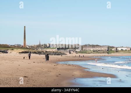 Les gens marchent sur la plage de Spittal avec Berwick upon Tweed en arrière-plan, Northumberland, Angleterre, Royaume-Uni Banque D'Images