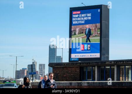29 mars 2025, Londres, Royaume-Uni. Un panneau d'affichage électronique affiche un reportage de LBC sur la déclaration de Donald Trump selon laquelle une prise de contrôle du Groenland par les États-Unis est nécessaire pour la paix dans le monde. Banque D'Images