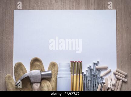 Les plans de compteur en bois feuille de clous de papier griffe marteau goujonnées chevilles et gants de sécurité en cuir sur le concept de construction d'espace de copie de panneau de bois Banque D'Images