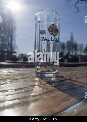 Verre à bière vide Paulaner sur une table de jardin de bière altérée, derrière elle visiteurs de jardin de bière, Kleinhesseloher See, Munich, Bavière, Allemagne, Europe Banque D'Images