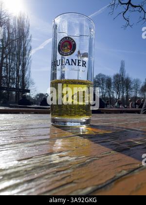Verre à bière Paulaner à moitié rempli sur une table de jardin de bière altérée, derrière elle visiteurs de jardin de bière, Kleinhesseloher See, Munich, Bavière, Allemagne, Europ Banque D'Images