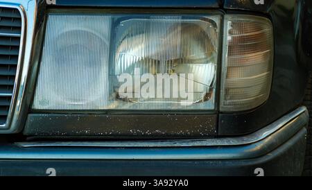 Une photo détaillée du phare halogène avant d'une Mercedes Benz 200 E, mettant en valeur la clarté et le design de la lumière classique. Banque D'Images