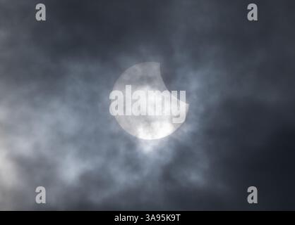 Berlin, Allemagne. 29 mars 2025. Début d'une éclipse solaire partielle dans le ciel légèrement couvert au-dessus du stade olympique de Berlin. Crédit : Soeren Stache/dpa/Alamy Live News Banque D'Images