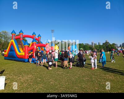Toronto, ON, Canada – 31 mai 2024 : les familles se rassemblent autour de grands toboggans gonflables et de parcours d’obstacles lors d’un événement pour enfants par un après-midi ensoleillé. Banque D'Images