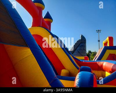 Toronto, ON, Canada – 31 mai 2024 : les familles se rassemblent autour de grands toboggans gonflables et de parcours d’obstacles lors d’un événement pour enfants par un après-midi ensoleillé. Banque D'Images