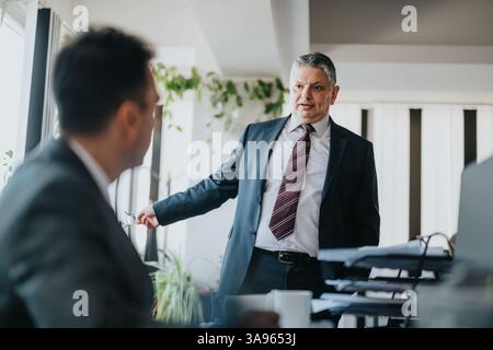 Discussion d'affaires entre gestionnaires dans un environnement de bureau professionnel Banque D'Images