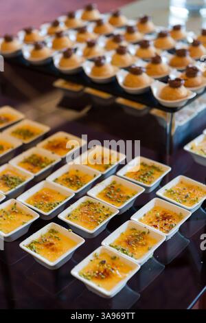 Une table élégante remplie de desserts et de pâtisseries, magnifiquement agencée pour un événement spécial, offrant une sélection alléchante de friandises sucrées. Banque D'Images