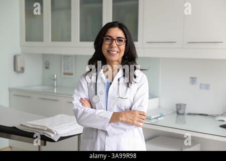 Heureuse médecin mature posant à l'hôpital Banque D'Images