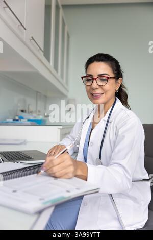 Praticien positif focalisé médecin femme écrivant des notes Banque D'Images