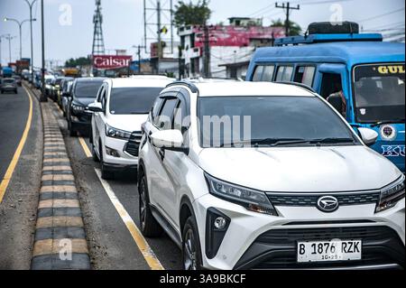 Les embouteillages pendant l'Eid Moubarak 1446 Hijri 'Mudik', ou Homecoming, à Medan, Sumatra du Nord, Indonésie, le 28 mars, 2025. les autorités indonésiennes se préparent à l'exode annuel, puisque 146 millions de personnes, soit plus de la moitié de la population, rentreront chez elles pour l'Aïd al-Fitr. Les autorités s'attendent à ce que le jour de pointe soit vendredi, avec 12 millions de personnes sur la route. Environ 33 millions de voyageurs utiliseront des voitures privées, 25 millions prendront des bus et 23 millions dépendront des trains, selon le ministère des Transports. Pour gérer la montée en puissance des voyages, plus de 164 000 agents de sécurité et Banque D'Images