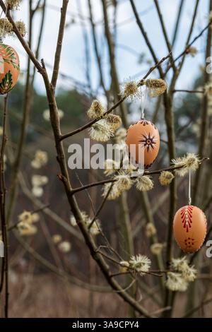 Zoom avant sur trois œufs de Pâques traditionnels peints à la cire suspendus sur des branches de saule Banque D'Images