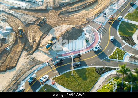 Conduite de voitures de circulation à l'intersection du rond-point en construction. Construire un cercle de circulation sur la route américaine avec des voitures en mouvement Banque D'Images