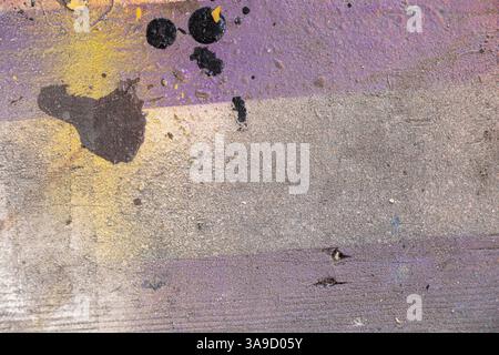 Peint des taches violettes et jaunes et blanches et noires sur une planche de bois comme fond, fond abstrait multicolore Banque D'Images