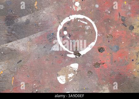 Marque blanche ronde d'une boîte debout sur un panneau multicolore dans un atelier de peinture, fond abstrait Banque D'Images
