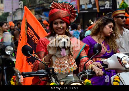 Mumbai, Inde. 30 mars 2025. MUMBAI, INDE - MARS 30 : les femmes s'habillent en tenue maharashtrienne traditionnelle des vélos de conduite avec son chien'Nia' lors du rassemblement Gudi Padwa sur leurs vélos à Girgoan, le 30 mars 2025 à Mumbai, Inde. Gudi Padwa est une fête importante célébrée par les hindous au Maharashtra, et Yugadi au Karnataka est observé le premier jour du calendrier lunisolaire hindou, tombant dans le mois de Chaitra, qui correspond à la fin mars et au début avril selon le calendrier grégorien. (Photo par Anshuman Poyrekar/Hindustan Times/Sipa USA ) crédit : Sipa USA/Alamy Live News Banque D'Images