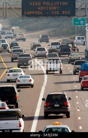 21 décembre 2005 ; Phoenix, AZ, États-Unis ; le trafic sur l'Interstate 10 dans le centre-ville de Phoenix, Arizona, passe sous un panneau d'affichage électronique avertissant les automobilistes des niveaux élevés de pollution atmosphérique dans la région de Phoenix. Phoenix et sa banlieue luttent contre les niveaux élevés de pollution particulaire, le « nuage brun », chaque hiver. Le nuage brun est constitué de minuscules particules de dioxyde de carbone et d'azote gazeux. Ces substances sont déposées dans l'air principalement par la combustion de combustibles fossiles. Les voitures, les engins de construction, les centrales électriques, les tondeuses à gazon, les souffleurs de feuilles et plus contribuent au nuage, qui se forme lorsque la pollution est piège Banque D'Images