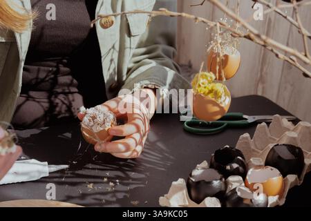 Femme méconnaissable créant une décoration de vacances de Pâques à partir de coquille d'œuf. DIY faites-le vous-même étape par étape instruction. Vacances de préparation artisanale Banque D'Images
