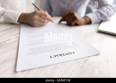 Gros plan du contrat sur la table avec les mains des femmes d'affaires Banque D'Images