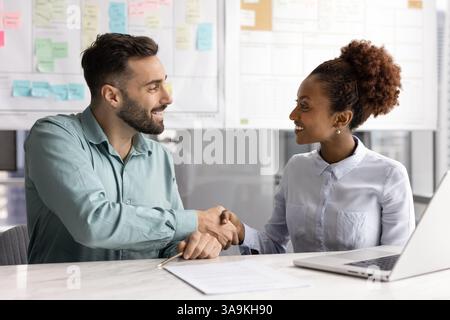 Joyeux collègues d'affaires divers et masculins donnant la poignée de main Banque D'Images