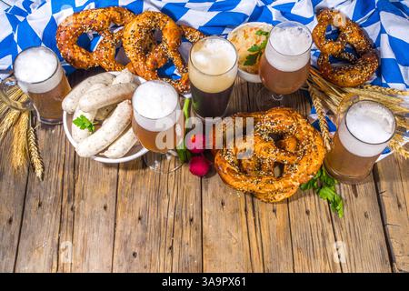 L'Oktoberfest propose une cuisine traditionnelle bavaroise pour les vacances, des saucisses avec bretzels, de la choucroute, du verre à bière et des tasses sur un bac éclairé au soleil en bois Banque D'Images