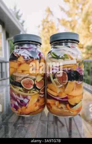 Deux pots remplis de fruits et légumes colorés pour fermentatio Banque D'Images