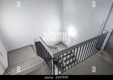 Hall d'escalier intérieur de bâtiment public. Au-dessus du point de vue, regardant vers le bas, marches descendant, grand angle, pas de gens. Banque D'Images
