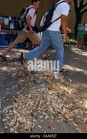 18 avril 2006 ; San Marcos, TX, États-Unis ; mardi, des étudiants marchant dans la zone Quad de l'Université d'État du Texas sautent par-dessus un désordre de mégots de cigarettes dressés par des membres de Earth First pour illustrer les problèmes de pollution depuis que fumer a été interdit dans la région. Crédit obligatoire : photo de Tom Reel/San Antonio Express-News/ZUMA Press. (©) Copyright 2006 par San Antonio Express-News Banque D'Images
