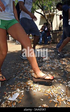 18 avril 2006 ; San Marcos, TX, États-Unis ; mardi, des étudiants marchant dans la zone Quad de l'Université d'État du Texas sautent par-dessus un désordre de mégots de cigarettes dressés par des membres de Earth First pour illustrer les problèmes de pollution depuis que fumer a été interdit dans la région. Crédit obligatoire : photo de Tom Reel/San Antonio Express-News/ZUMA Press. (©) Copyright 2006 par San Antonio Express-News Banque D'Images