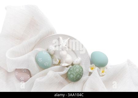 Élégants oeufs de pâques et lièvre en porcelaine sur toile de lin sur plaque blanche. Joyeuses Pâques concept. Vue de dessus. Avec de l'espace pour votre texte Banque D'Images