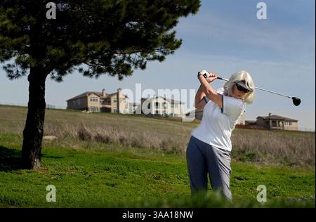 Jamie Brockardt (CQ) de Fair Oaks retire la pilote pour son tir au sixième trou du terrain de golf El Dorado Hills jeudi 21 février 2002. Le parcours vieux de 40 ans, qui s'adresse principalement aux personnes âgées et aux jeunes, a du mal à s'intégrer au marché du golf d'aujourd'hui, avec la prolifération de nouveaux parcours plus difficiles. Les revenus sont en baisse, la concurrence est en hausse, et cette vénérable course devrait se terminer plus tard cette année. En arrière-plan, de nouvelles maisons sont construites dans le développement Serrano, ce qui contribue également à la disparition éventuelle du parcours. (Sacramento Bee/Chr Banque D'Images