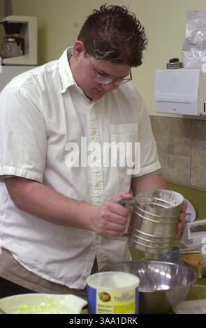 Bret Mackey 16, un junior à Kennedy High School, tamise de la farine pour un gâteau au café qu'il préparait dans un cours de cuisine avancée, le jeudi 21 février 2002. Kelly Dalisa l'instructeur enseigne les bases de la classe dans la gestion de restaurant et la restauration. Sacramento Bee/Jay Mather/ZUMA Press Banque D'Images