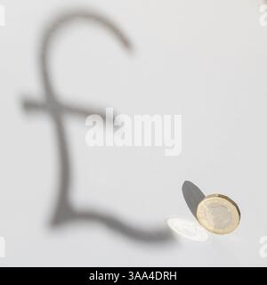 Pièce britannique d'une livre jetant une ombre sous la forme d'un symbole de livre - métaphore visuelle de la valeur monétaire, de l'économie et du concept financier Banque D'Images