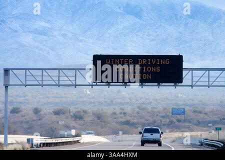 22 janvier 2007 ; Phoenix, Arizona, États-Unis ; un panneau routier sur l'AZ 87 avertit les automobilistes des conditions de conduite hivernale tandis que les montagnes McDowell, au nord de Phoenix, offrent une toile de fond enneigée. Le centre de l'Arizona a reçu une rare couverture de neige dimanche. La neige a été enregistrée dans la banlieue de Phoenix pour la première fois depuis 1998. Payson, dans les montagnes à 80 miles au nord de Phoenix, a reçu presque 10 pouces de neige. Plusieurs routes entre Phoenix et les collectivités périphériques ont été fermées à cause de la neige et de la glace. Crédit obligatoire : photo de Jack Kurtz/ZUMA Press. (©) Copyright 2007 par Jack Kurtz Banque D'Images