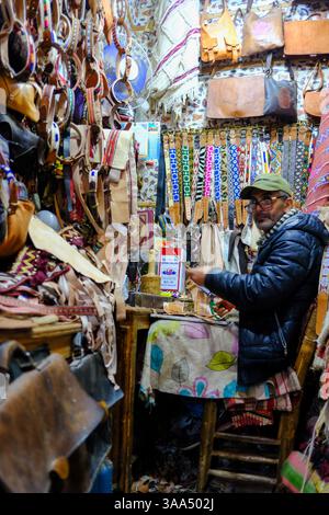 01 Jan 2025 - Marrakech, Maroc - Un stand local dans un souk à Marrakech assis et attendant des clients Banque D'Images
