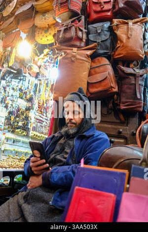 01 Jan 2025 - Marrakech, Maroc - Un stand local dans un souk à Marrakech assis et attendant des clients Banque D'Images