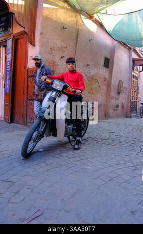 01 Jan 2025 - Marrakech, Maroc - Un garçon sur un vélo se précipitant à travers les voies étroites de ruelle et les routes dans la vieille ville de Marrakech. Banque D'Images
