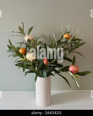 Œufs de Pâques colorés nichés parmi les feuilles vertes, créant une scène printanière festive et vibrante. Banque D'Images