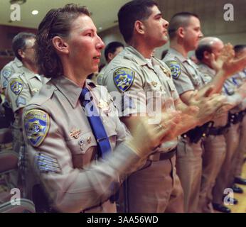 Les officiers de la California Highway Patrol Amy Mangan à gauche ; Mark Garcia à droite et à côté de Mangan (autres officiers non identifiés) applaudissent le nouveau membre du corps, Austin Creech 5, qui a été honoré aujourd'hui, le 9 mars 2001 lors d'une cérémonie spéciale de remise des diplômes. Creech, diagnostiqué avec un cancer du cerveau en phase terminale, a toujours voulu être policier. Le CHP a pris sa cause et l'a équipé d'un uniforme spécialement fabriqué. Au cours de la cérémonie de remise des diplômes, Austin reçut son insigne d'officier, ses bars de capitaine et de nombreux autres moments en l'honneur de sa bravoure et de son inspiration envers tous les officiers du CHP. Sacramento Banque D'Images