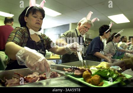 Inez Reyes (cq), à gauche, et Mike Roy, tous deux bénévoles de la paroisse Francis de Sacramento, servent un repas de Pâques pour les sans-abri à Loaves & Fishes le dimanche 15 avril 2001. Tous les bénévoles étaient vêtus d'oreilles de lapin, de queues et de noeuds papillon blancs alors qu'ils servaient du jambon, des haricots verts, des pommes de terre, une salade verte et des gâteaux à la tasse aux nombreux sans-abri de la région. (Sacramento Bee/Jose M. Osorio) Sacramento Bee/ZUMA Press Banque D'Images