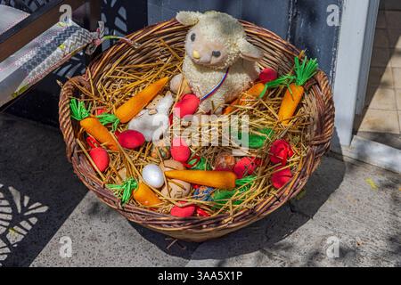 Petit agneau avec œufs de Pâques et carottes dans panier de paille décoration printanière Banque D'Images