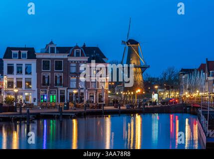 Ville hollandaise de Leyde au crépuscule, moulin à vent historique, canaux Reflections et vie nocturne luisante Banque D'Images