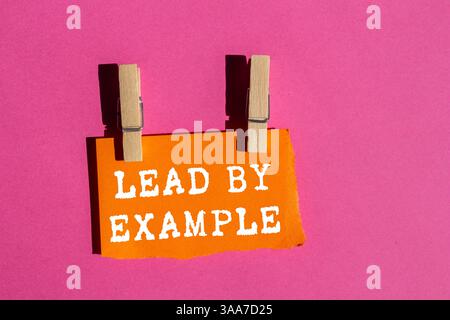 Dirigez par exemple le message écrit sur un papier orange déchiré déchiré sur fond rose. Symbole de la direction conceptuelle par exemple. Copier l'espace. Banque D'Images