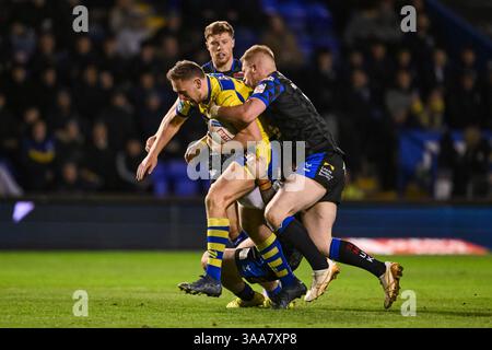 WARRINGTON, ANGLETERRE - 28 MARS 2025 : Ben Currie de Warrington Wolves est attaqué par James Bentley de Leeds Rhinos lors de la Betfred Super League Roun Banque D'Images