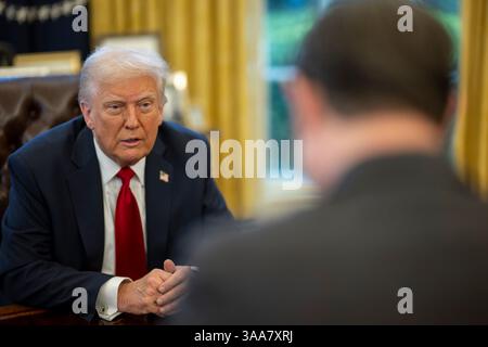 Washington, États-Unis. 26 mars 2025. U. Le président Donald Trump, s’entretient avec le président de la Chambre Mike Johnson, R-LA, à droite, avant de signer un décret augmentant les tarifs sur tous les véhicules importés au Bureau ovale de la Maison Blanche, le 26 mars 2025 à Washington, DC crédit : Daniel Torok/White House photo/Alamy Live News Banque D'Images