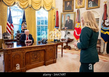 Washington, États-Unis. 26 mars 2025. U. Le président Donald Trump, s’entretient avec Karoline Leavitt, attachée de presse de la Maison Blanche, à droite, avant de signer un décret augmentant les tarifs sur tous les véhicules importés au Bureau ovale de la Maison Blanche, le 26 mars 2025 à Washington, DC crédit : Daniel Torok/White House photo/Alamy Live News Banque D'Images