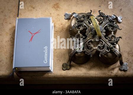 Sexueller Missbrauch in der katholischen Kirche. 22.12.2023, UE, DEU, Deutschland, Bayer, Garching an der Alz : Die Römisch-katholische Pfarrkirche : Nikolaus. Nikolaus Statue. Bibel und Ministrantenschelle bzw. Handglocke die von Ministranten im Gottesdienst genutzt werden. In den Räumen der Kirchegemeinde wurde u.a. Andreas Perr, durch den Kaplan Peter H. sexuell Missbrauchs. Andreas Peer War Ministrant der katholischen Kirche in Garching an der Alz und wurde 1996 sexuell missbraucht. Kaplan H. War nach pädophilen Missbrauchsfällen in Bottrop und Essen mit Wissen darum von der katholisc Banque D'Images